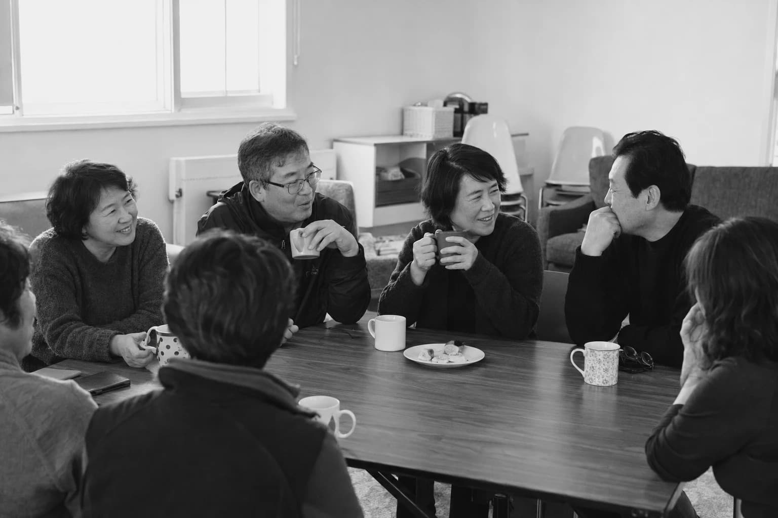 식탁에 둘러앉아 커피를 마시며 이야기를 나누는 교우들